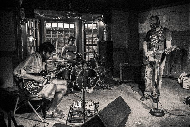 A black and white photo of a band playing indoors at Mike and Molly's