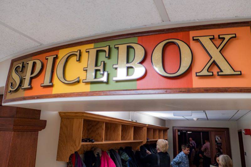 A sign with orange, yellow, green, and red blocks. The word SPICEBOX is in beige block letters.