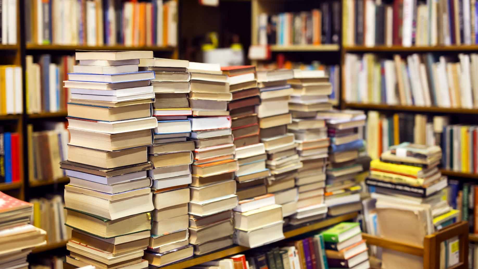 Multiple stacks of books on a table