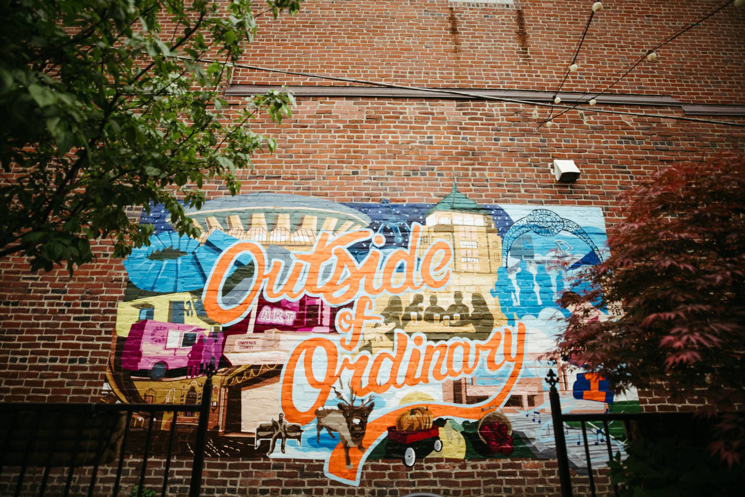 A brick wall featuring a mural stating "Outside of Ordinary"