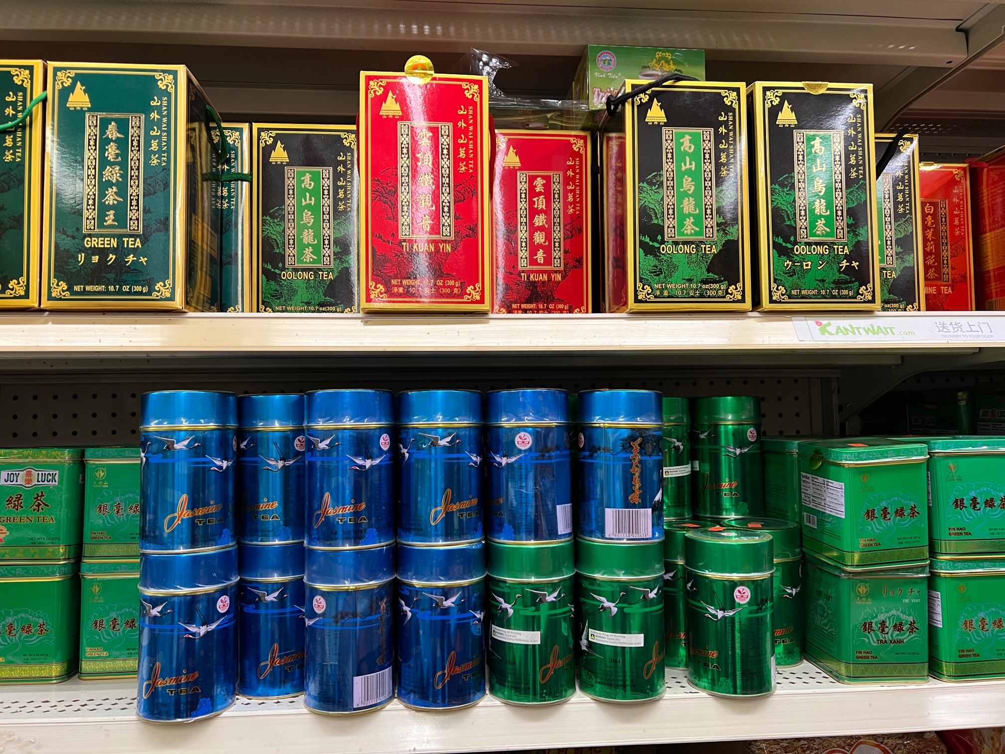 On the shelves at Far East Grocery, there are blue and green metallic canisters of green tea. Photo by Alyssa Buckley.