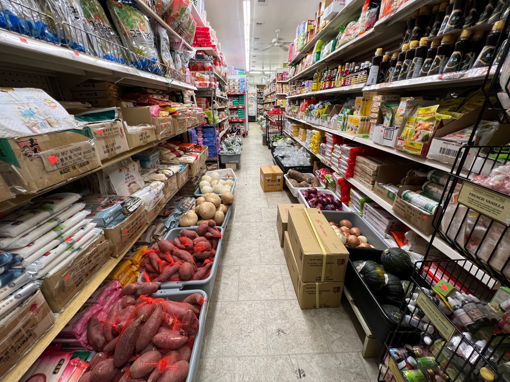Inside Far East Grocery, there are shelves of products and boxes of produce on the floor. Photo by Alyssa Buckley.