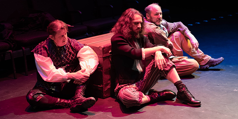 Three male actors seated on the stage talking. From the CUTC's production of The Tempest.