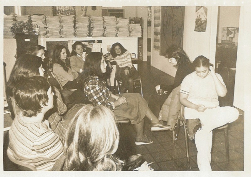 A black and white photo from the early 70s. Women are gathered and seated in chairs in a small room. Photo from RACES website.