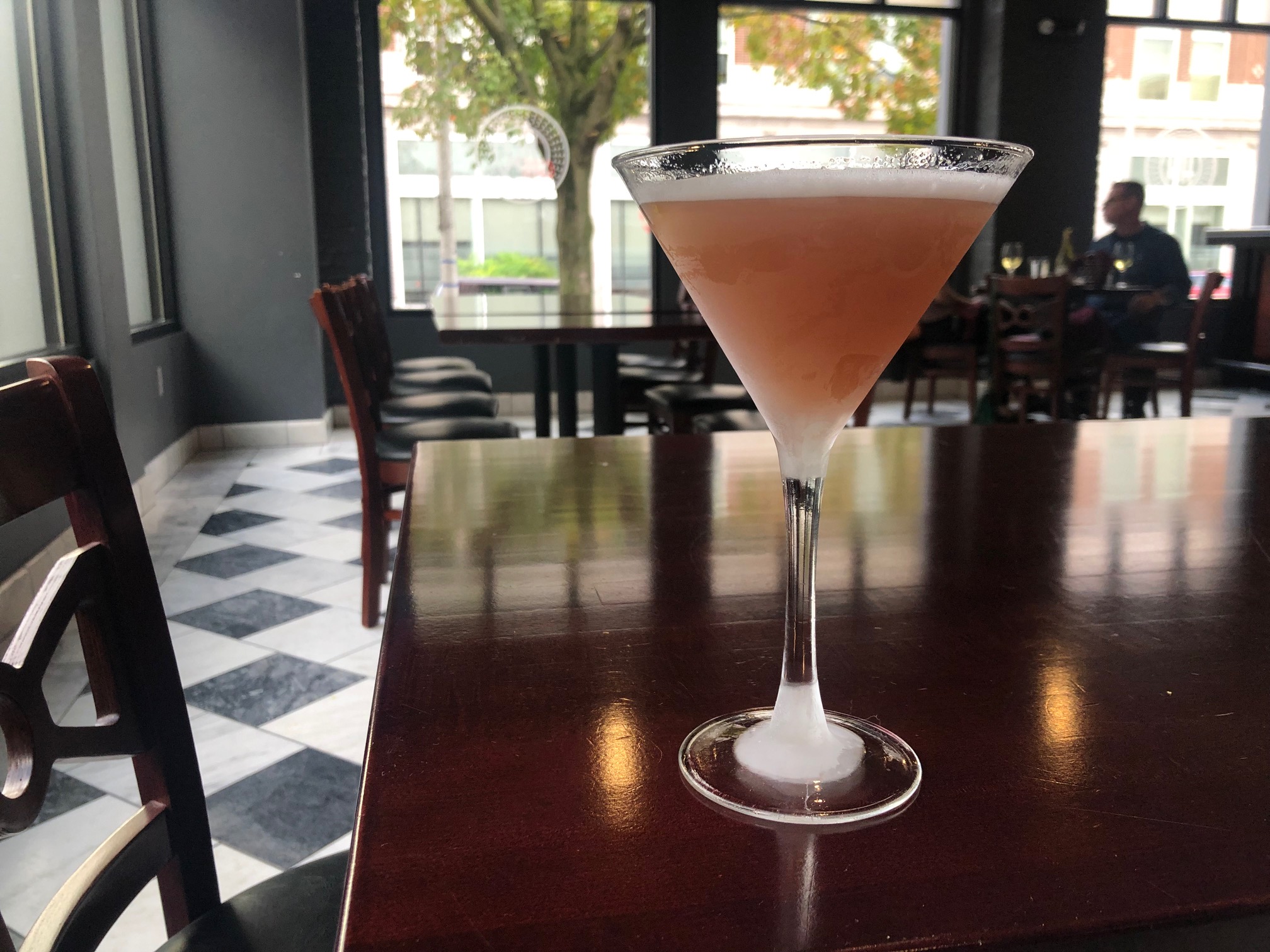 On a dark table in Hamilton Walker's front bar area, there is a French martini, a peach drink in a martini glass. Photo by Alyssa Buckley.