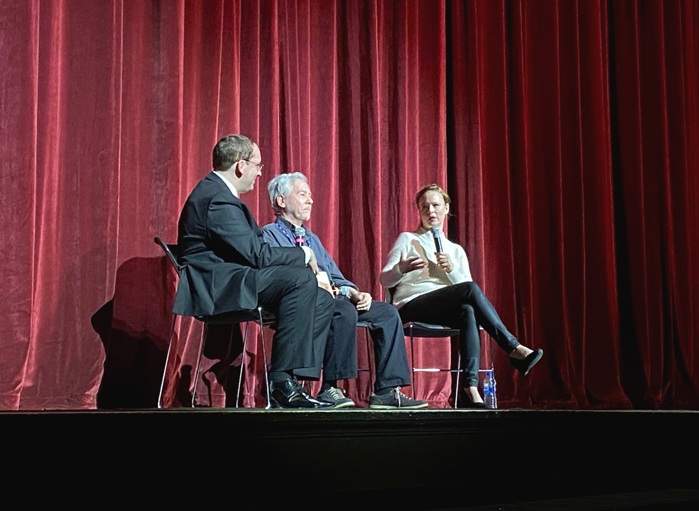 Thora Birch, Terry Zwigoff, and and editor from RogerEbert.com sit on the stage at the Virginia Theater. The red curtain is behind them, and they are in conversation. Photo by Jessica Hammie. 