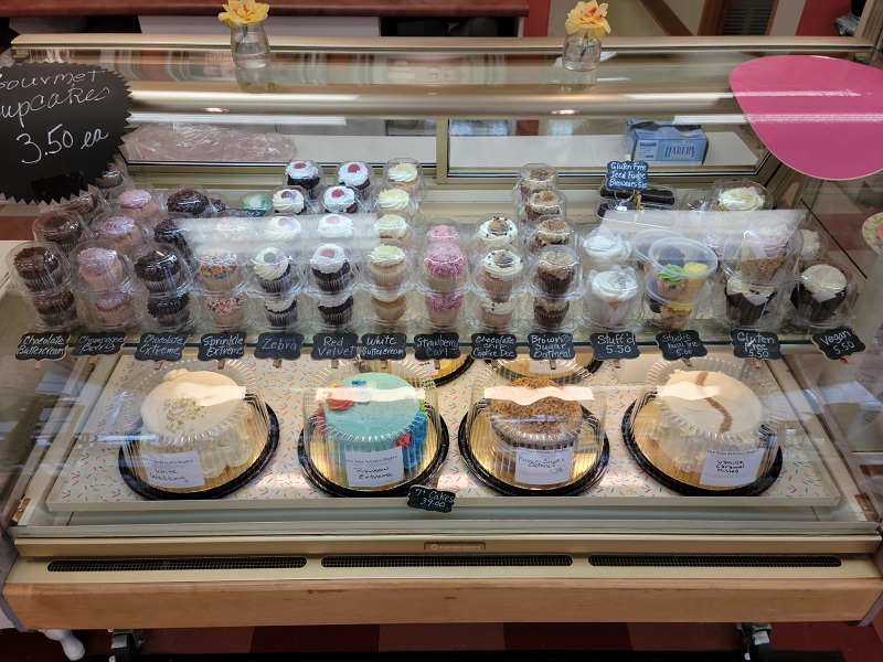 Cupcakes, large cakes, and brownies in a horizontal display case. Photo by Matthew Macomber.