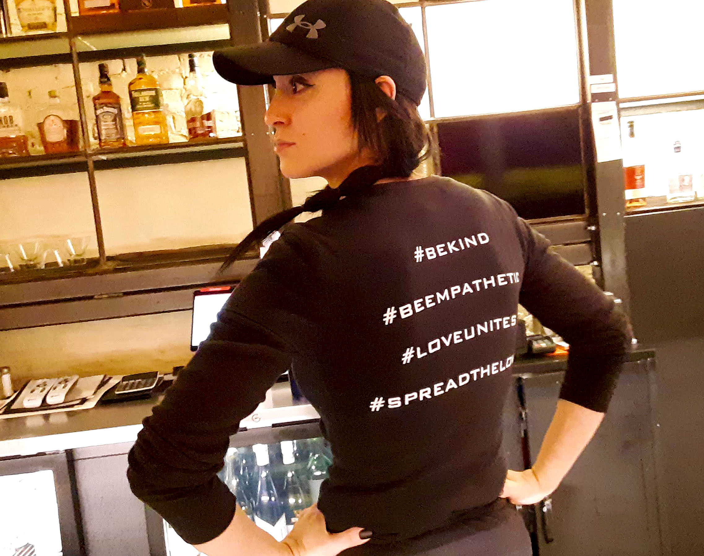 A server shows off the back of her black t-shirt with different positive hashtags. Photo by Paul Young.