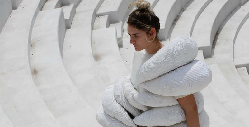 Cropped photo of woman modeling puffy white repurposed dress in the Krannert Center outdoor amphitheater steps. 