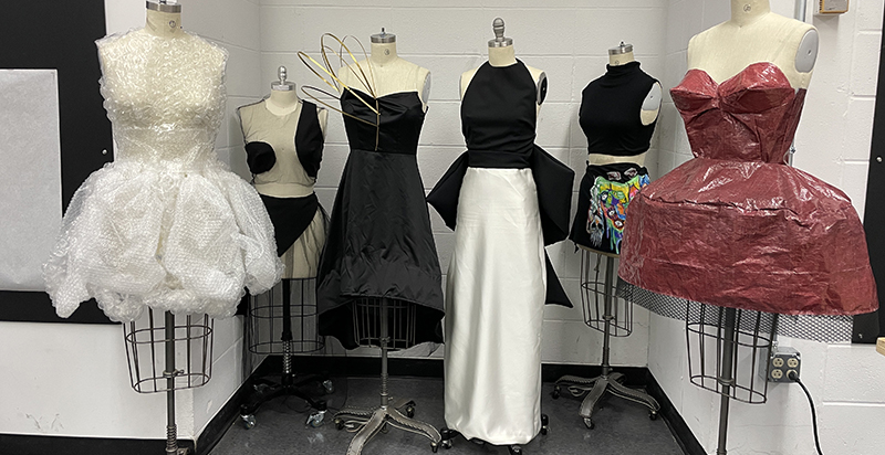 A variety of looks from the Re-Fashioned show styled on dress dummies in the classroom.
