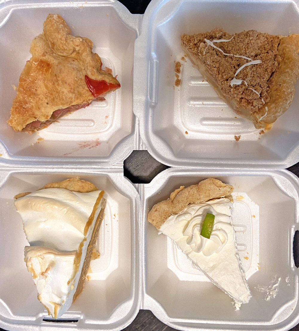 Four slices of pie in individual Styrofoam containers are laid out in a square on a table. Photo by Jessica Hammie. 