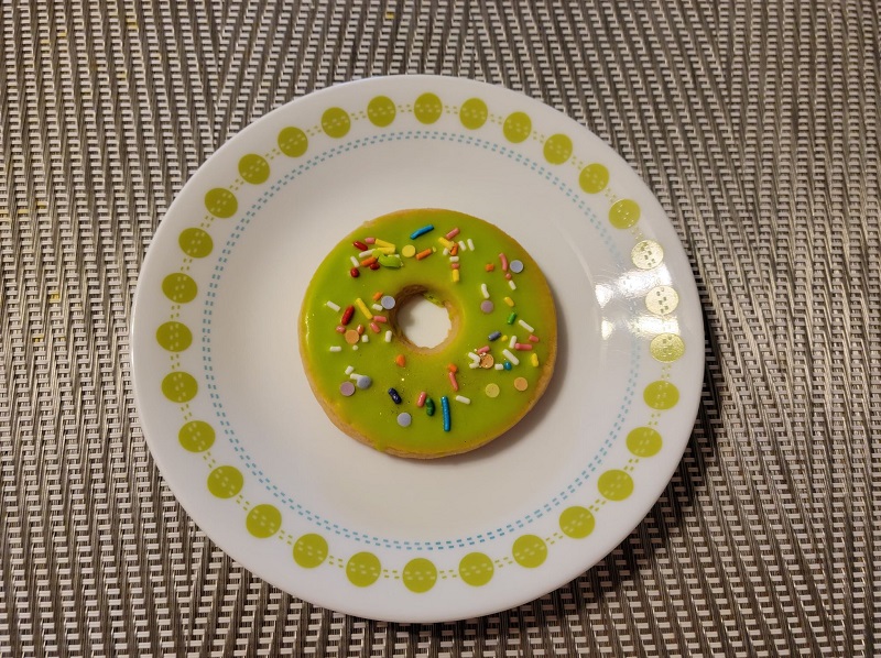 A green-frosted Scottish shortbread cookie on a white circle plate with a green dotted border. Photo by Matthew Macomber.