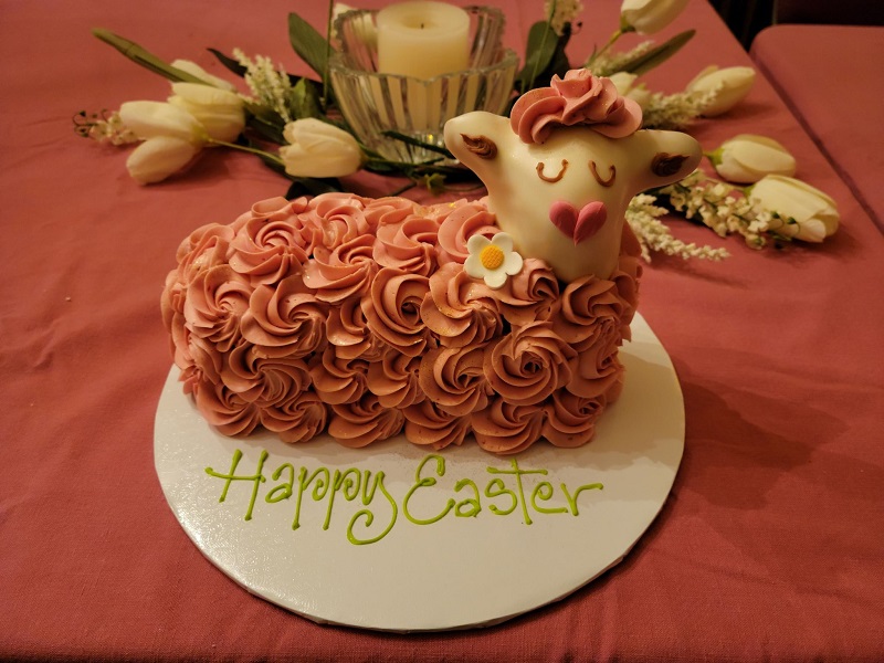 A strawberry lamb cake with â€œHappy Easterâ€ written on the cardboard circle the cake sits on. Photo by Matthew Macomber.