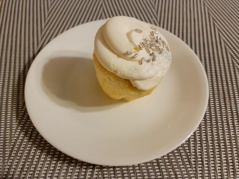 A stuffed white wedding cake cupcake on a white circle plate. Photo by Matthew Macomber.