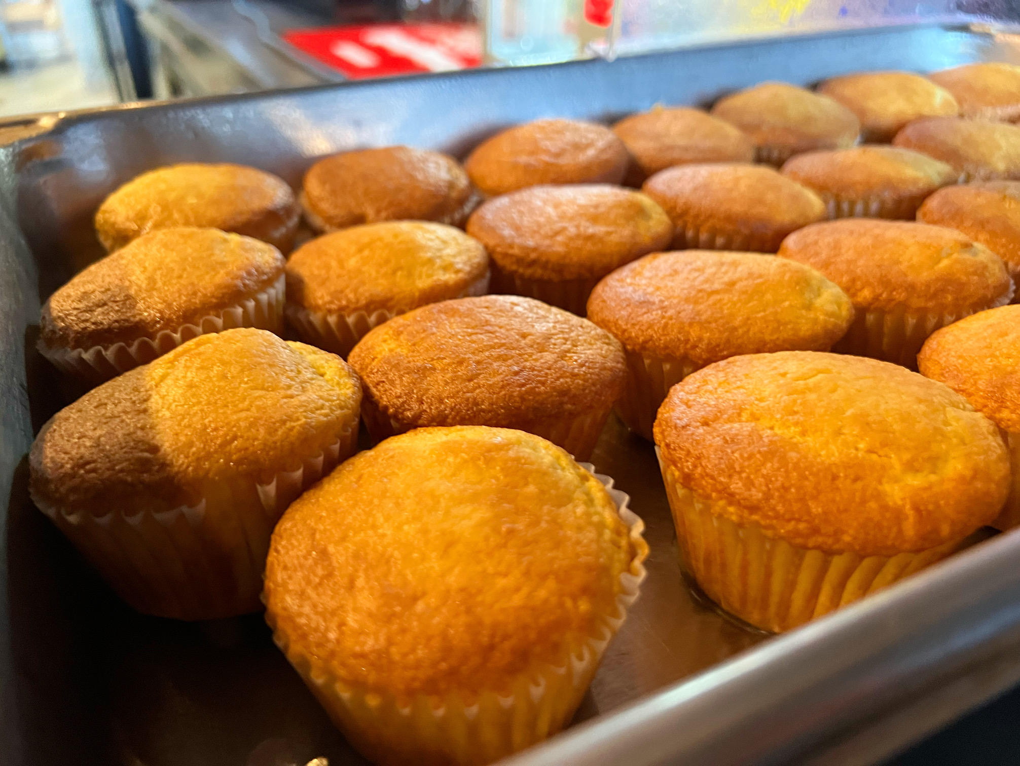 A silver tray holds rows of golden cornbread muffins. Photo by Alyssa Buckley.