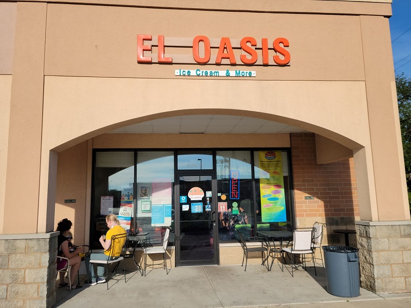 Outside of El Oasis with two sets of tables and chairs around them. Photo by Matthew Macomber.