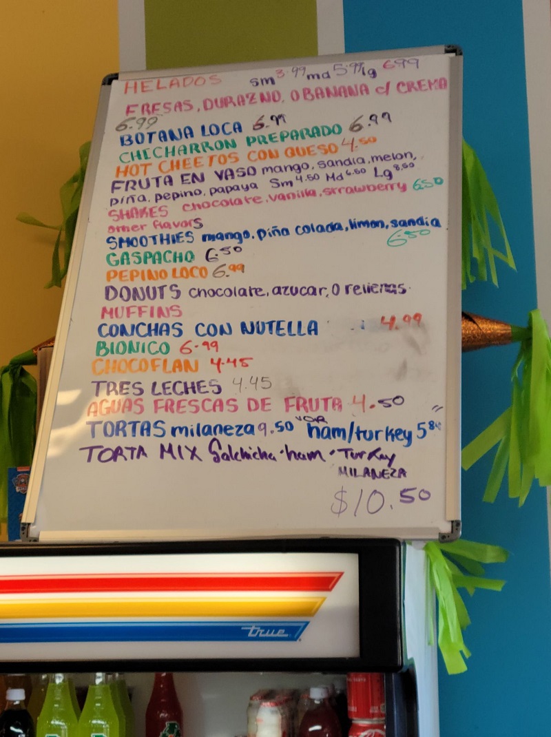 A white board menu of El Oasis with prices ranging from $3.99 to $10.50. Photo by Matthew Macomber.