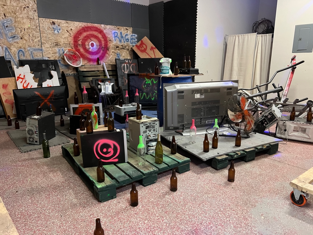 A full section of the warehouse at Rage Room Champaign has empty glass bottles, machines, and tvs for smashing. Photo by Alyssa Buckley.