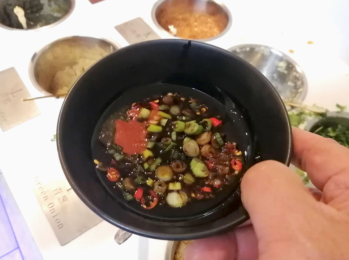 An close-up view of one bowl filed with a custom mix of condiments ingredient. Photo by Paul Young