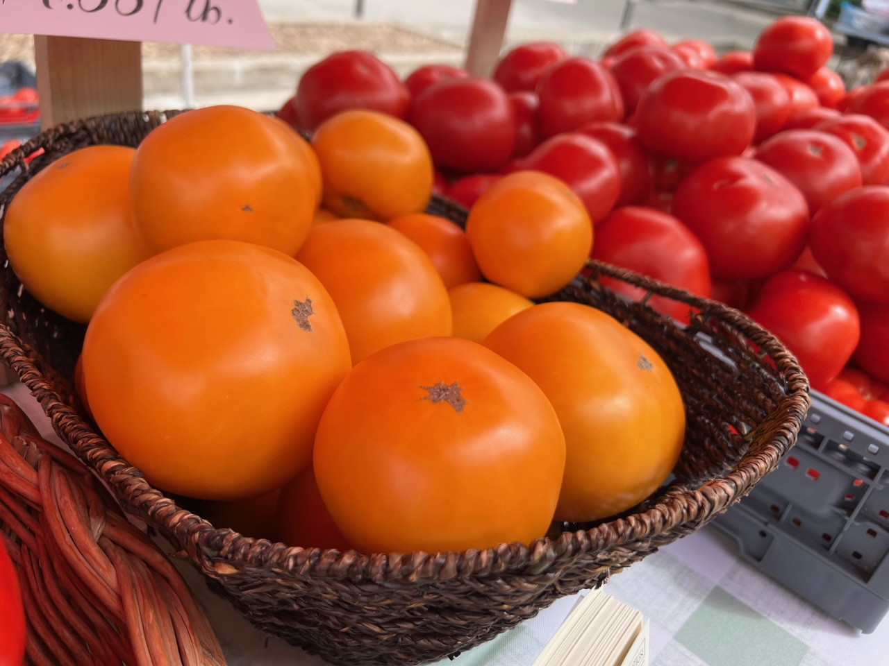 Baskets of orange and red tomatoes from Fruitful Vines are for sale at the Urbana Market at the Square. Photo by Alyssa Buckley.