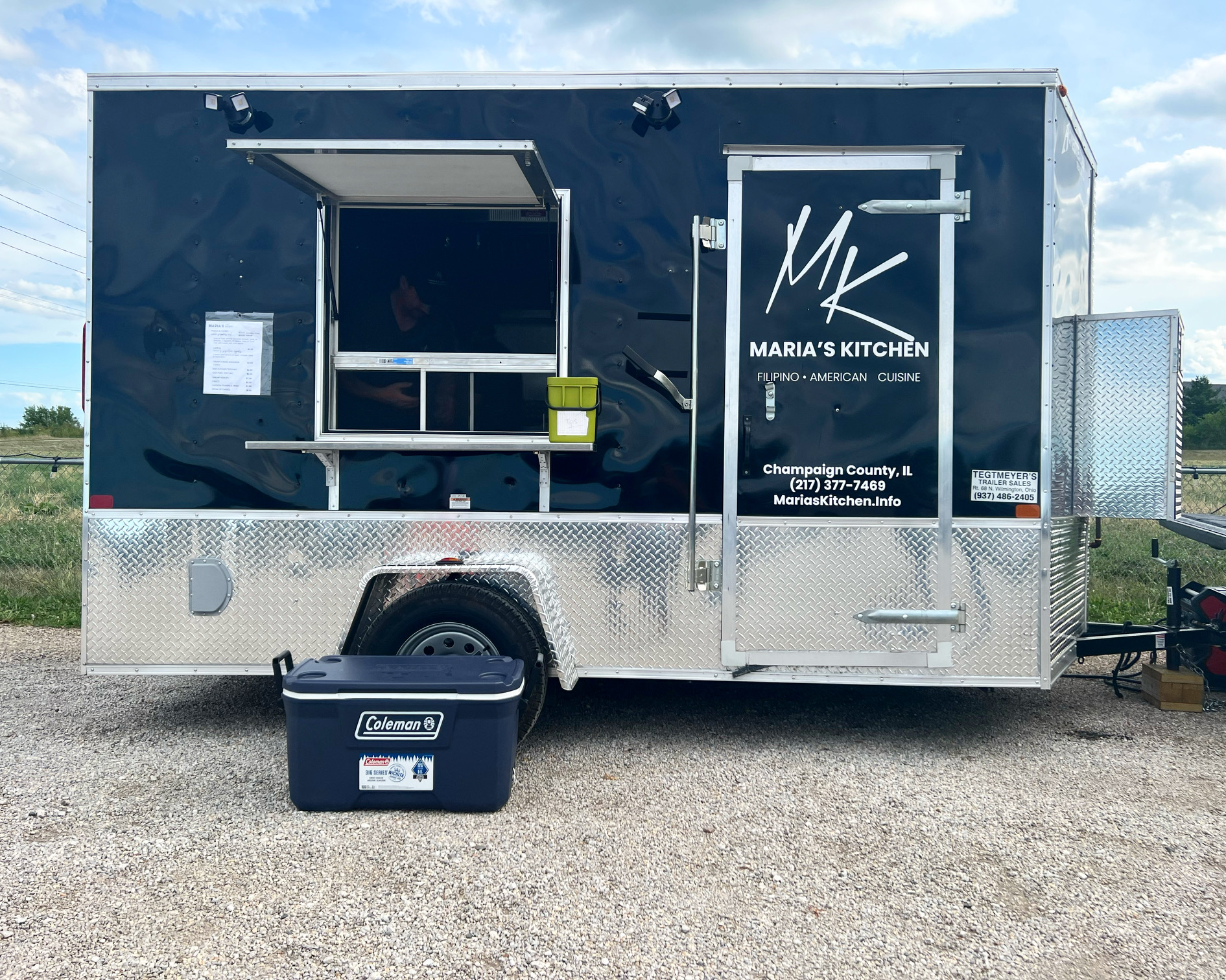 In the Riggs parking lot, there is a black food truck trailer for Maria's Kitchen with a black cooler in front. Photo by Alyssa Buckley.