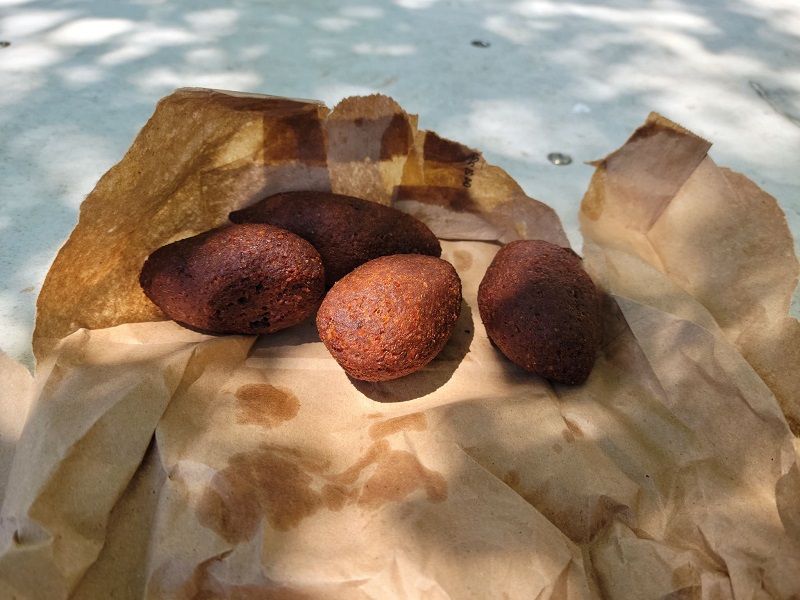 Four kibbeh on a broken open paper bag. Photo by Matthew Macomber.