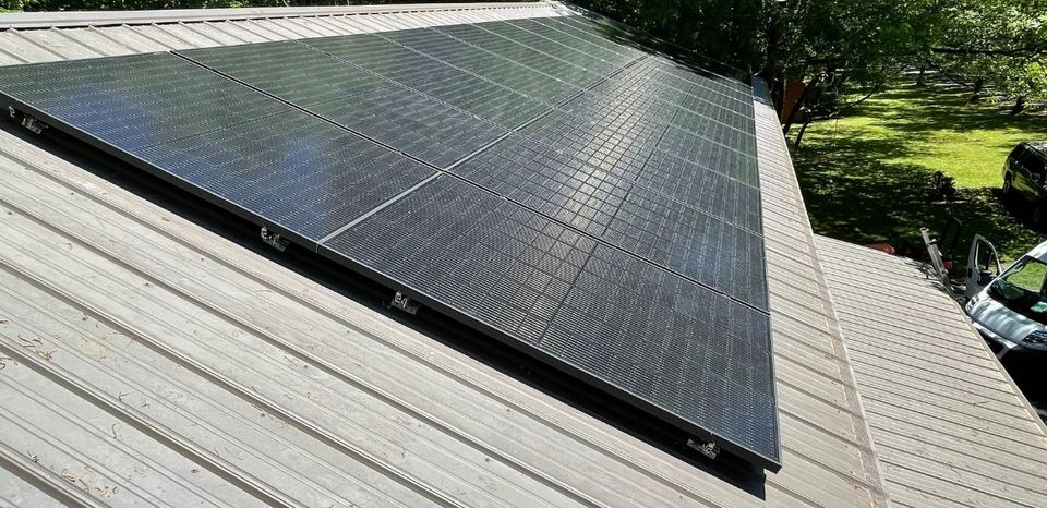 A solar panel attached to a slanted roof.