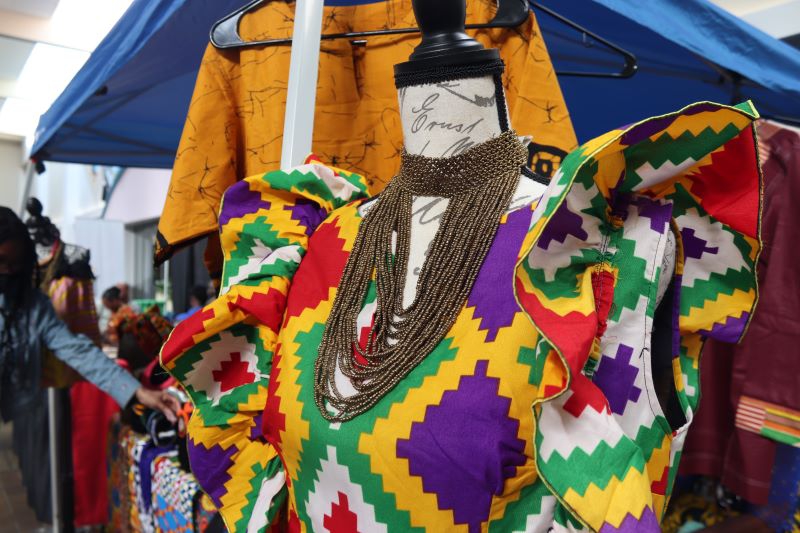 A colorful patterned dress on a mannequin with a beaded necklace. Photo by Maddie Rice.