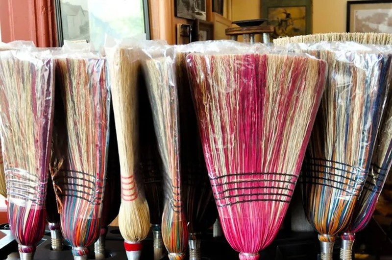 A row of colorful broom heads. Photo from Arcola Chamber of Commerce website.