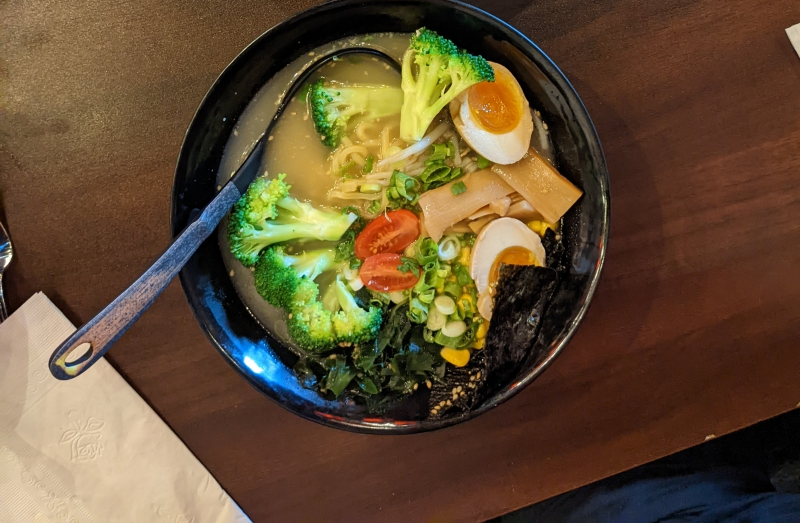 vegetable ramen. Broccoli, bamboo, seaweed, seasoned egg and tomato can all be seen in a pale broth. Photo by Caitlin Aylmer.