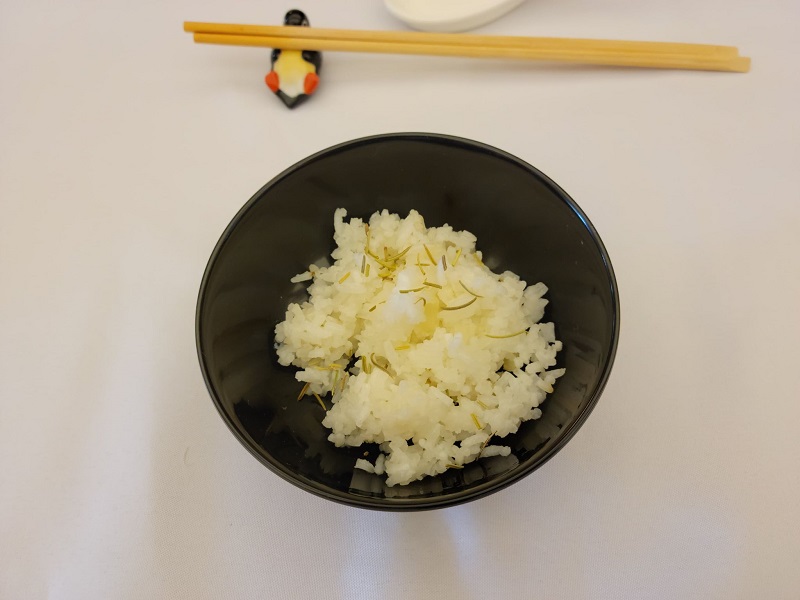 Garlic fried rice in a small bowl with rosemary on top of the rice. Photo by Matthew Macomber.