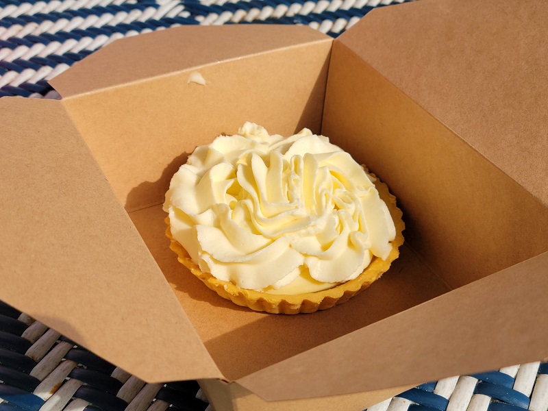 In a paper box, there is a banana cream tart. Photo by Matthew Macomber.