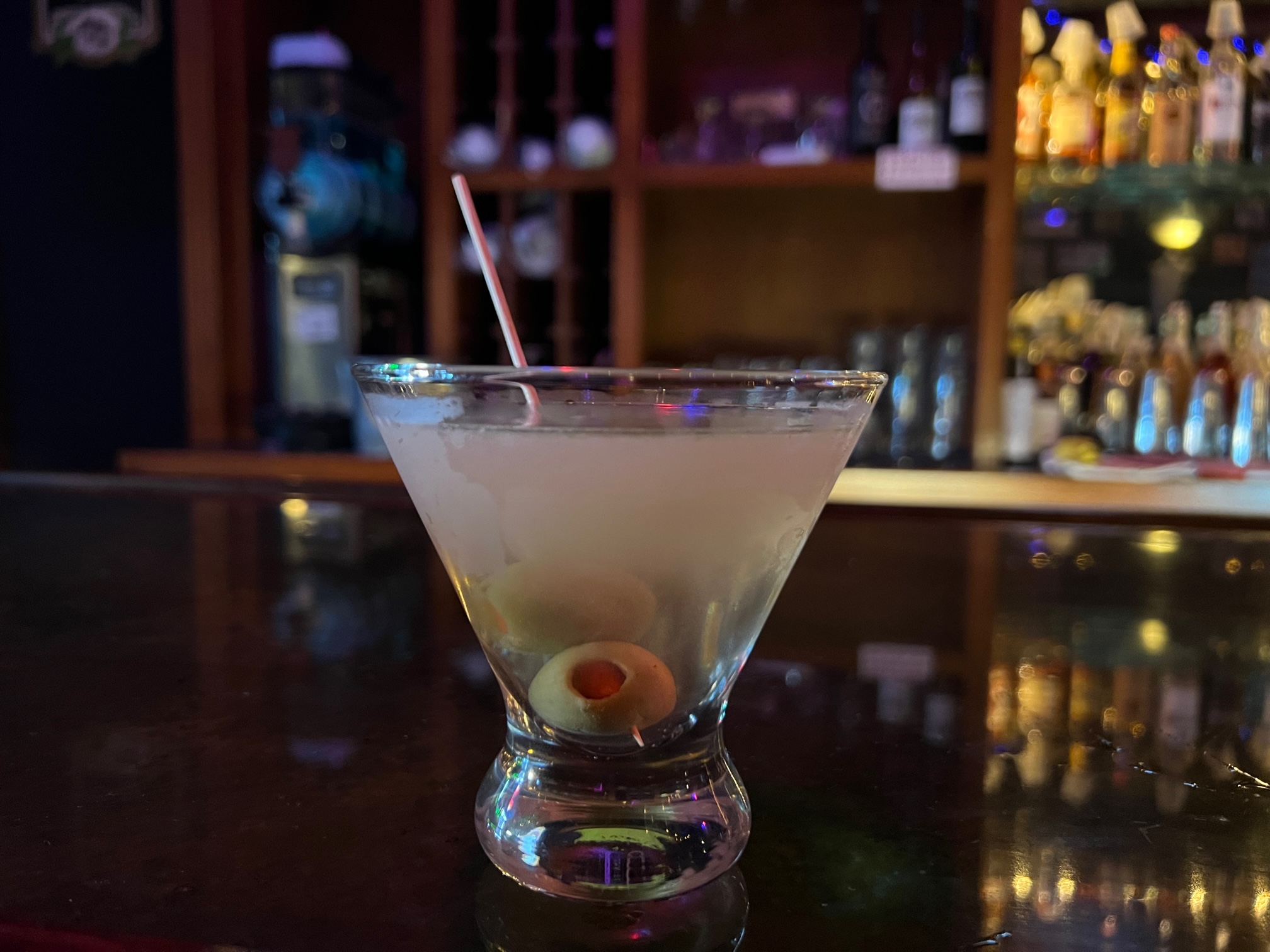 An olive is at the bottom of a cloudy cocktail. Photo by Alyssa Buckley.