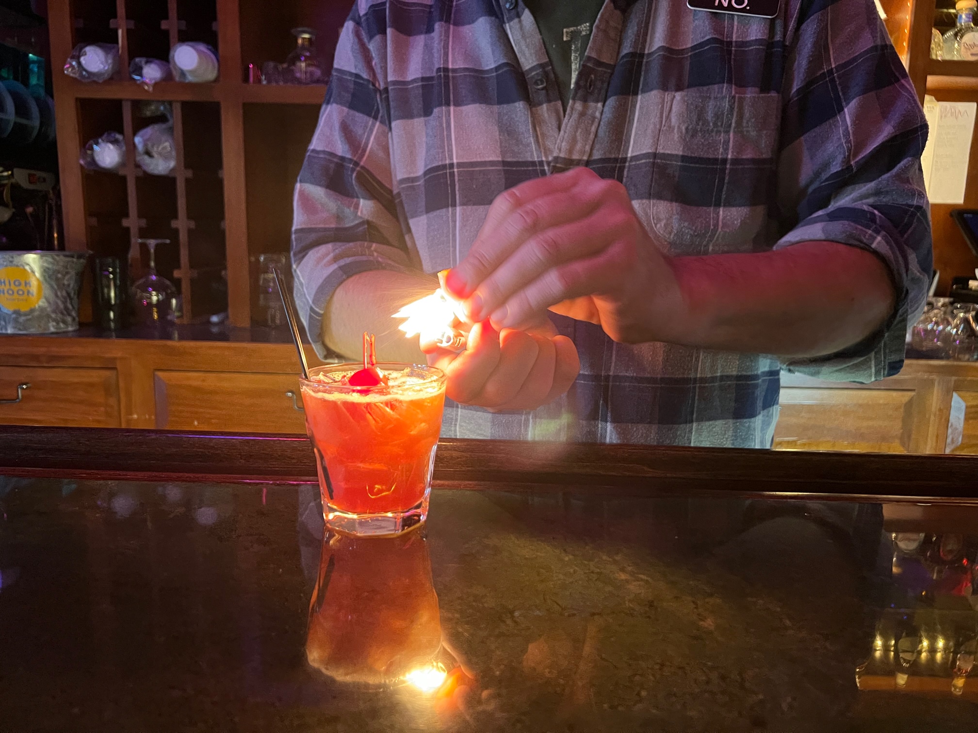 A bartender flames a citrus peel over an old fashioned at Bentley's Pub. Photo by Alyssa Buckley.