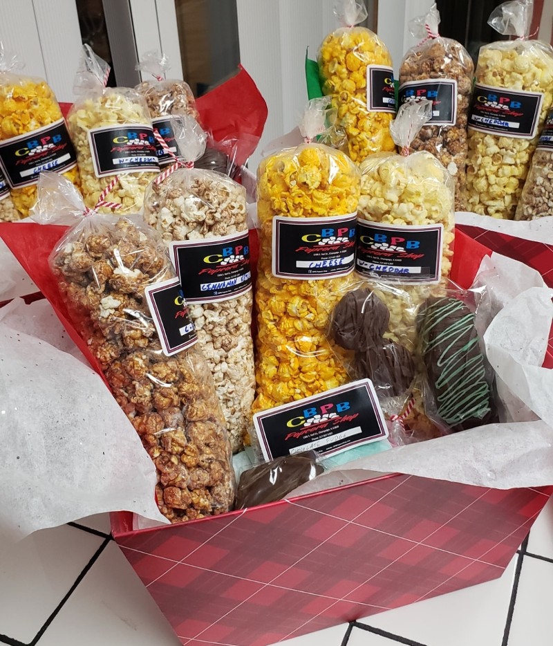 A red gift basket has several tall plastic bags filled with different flavored popcorn. Photo from CBPB Facebook page.