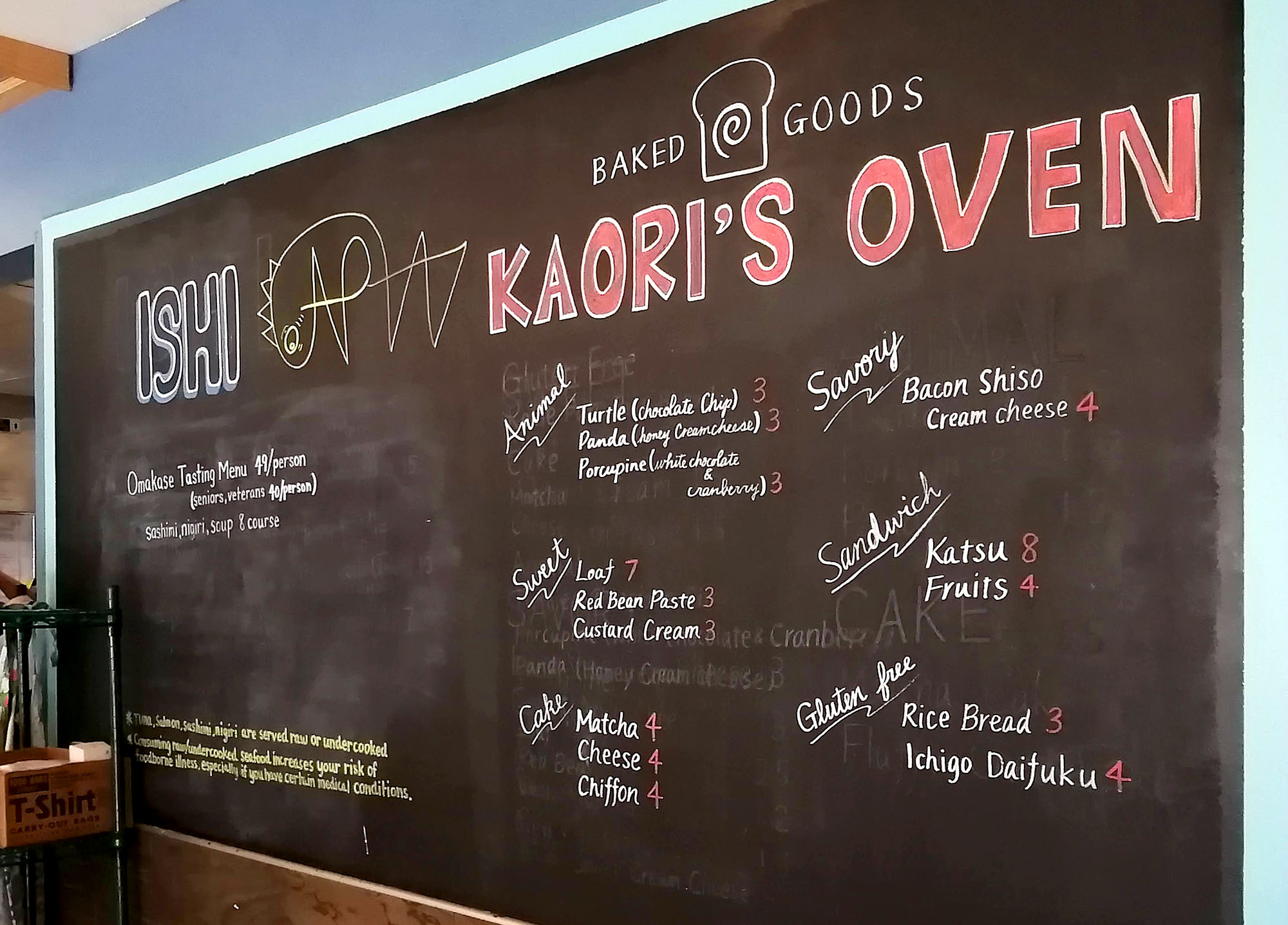 A handwritten blackboard with â€œISHIâ€ and â€œKaoriâ€™s Ovenâ€ clearly drawn at the top; the small type describes the omakase tasting menu and several bakery items for sale. Photo by Paul Young.