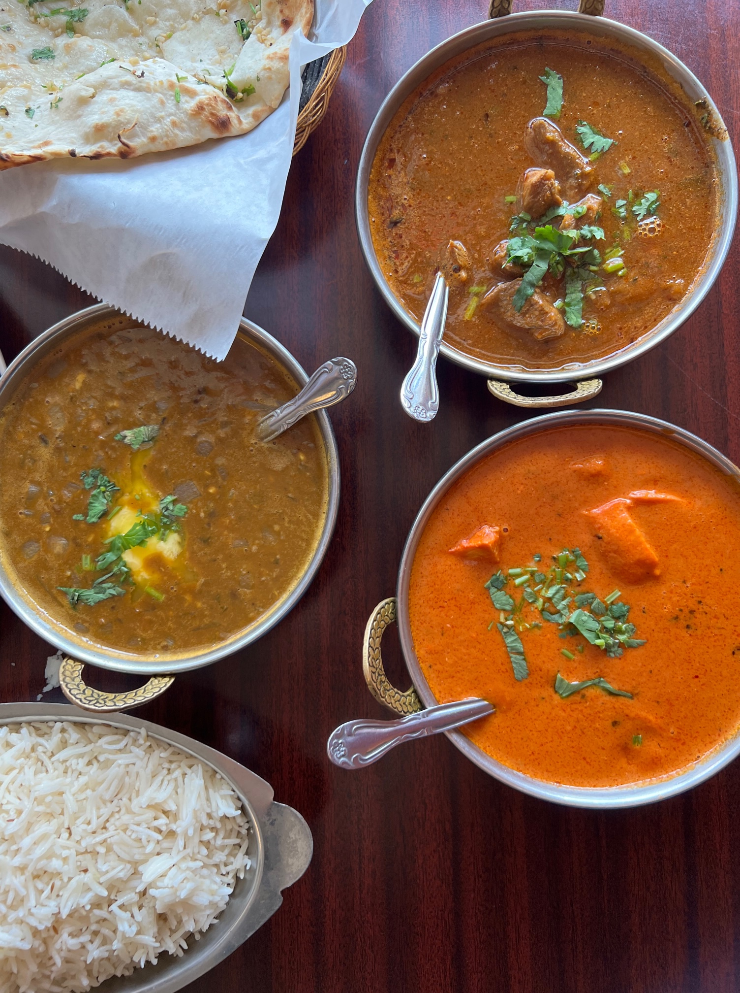An overhead photo of three saucy dishes from Ambar India Restaurant. Photo by Alyssa Buckley.
