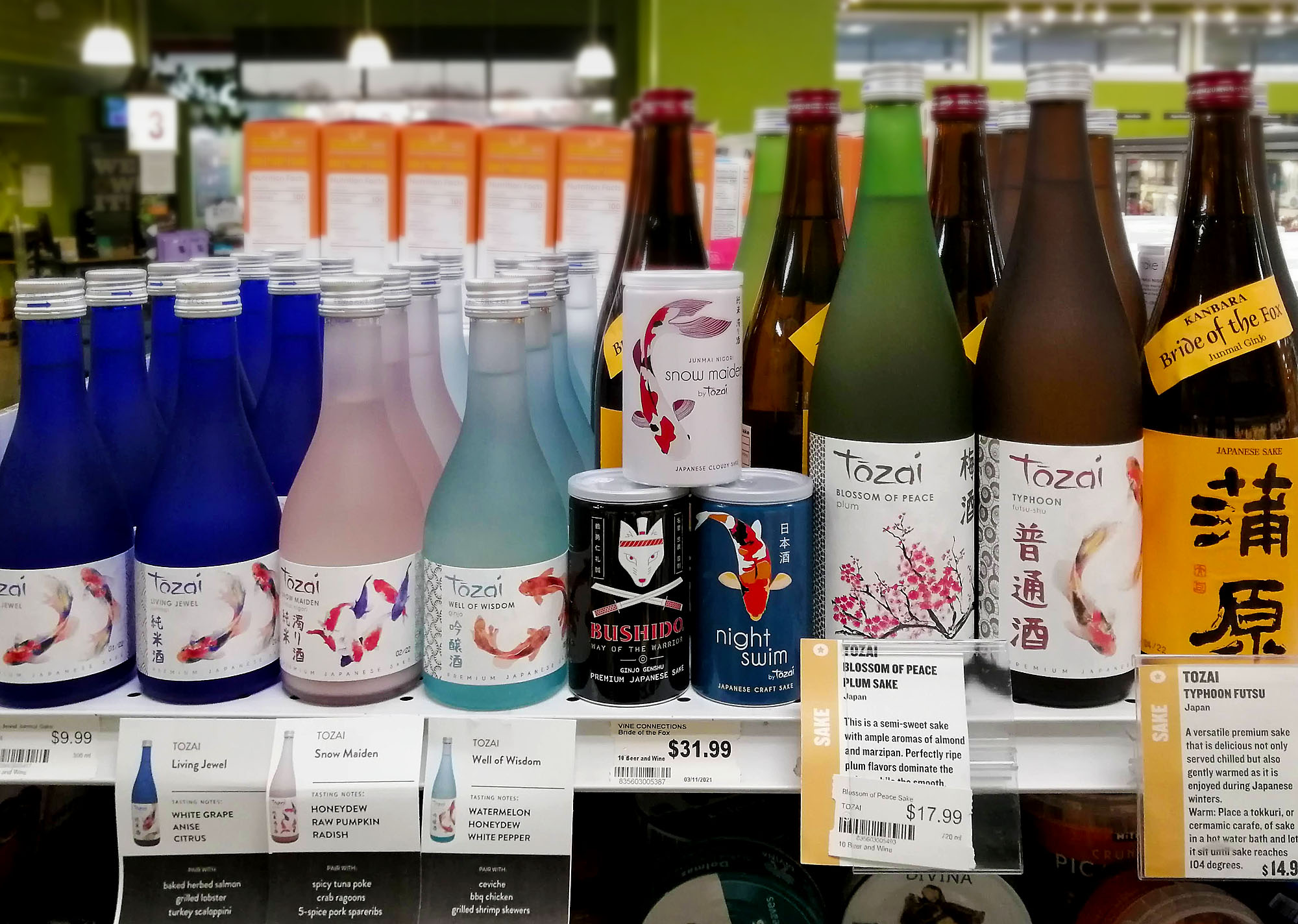 A display of various sake drinks in bottles and cans on a grocery shelf. Photo by Paul Young.