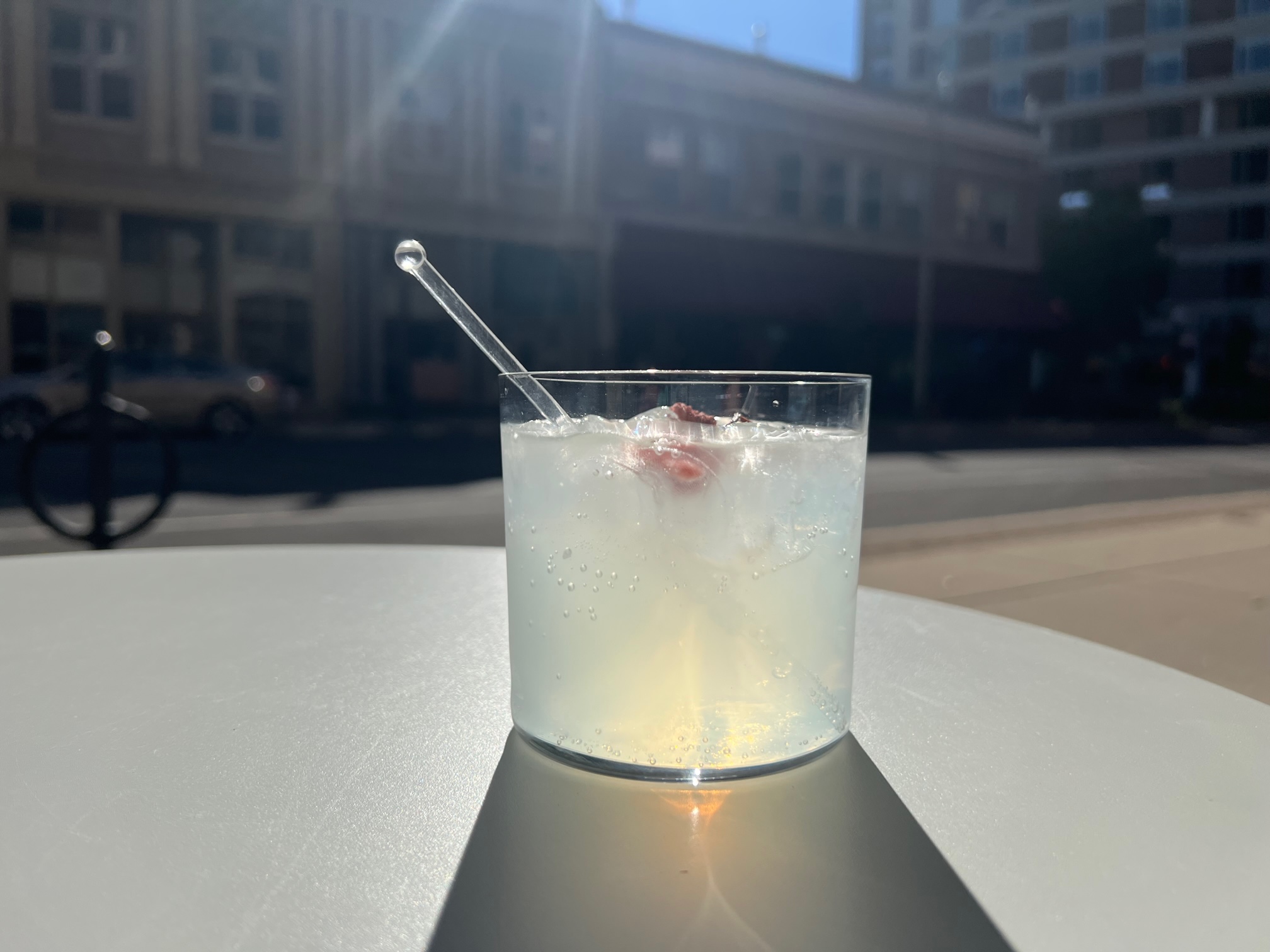 Ladro Enoteca's gin and tonic sits on an outdoor table with the afternoon sun shining on Downtown Champaign. Photo by Alyssa Buckley.