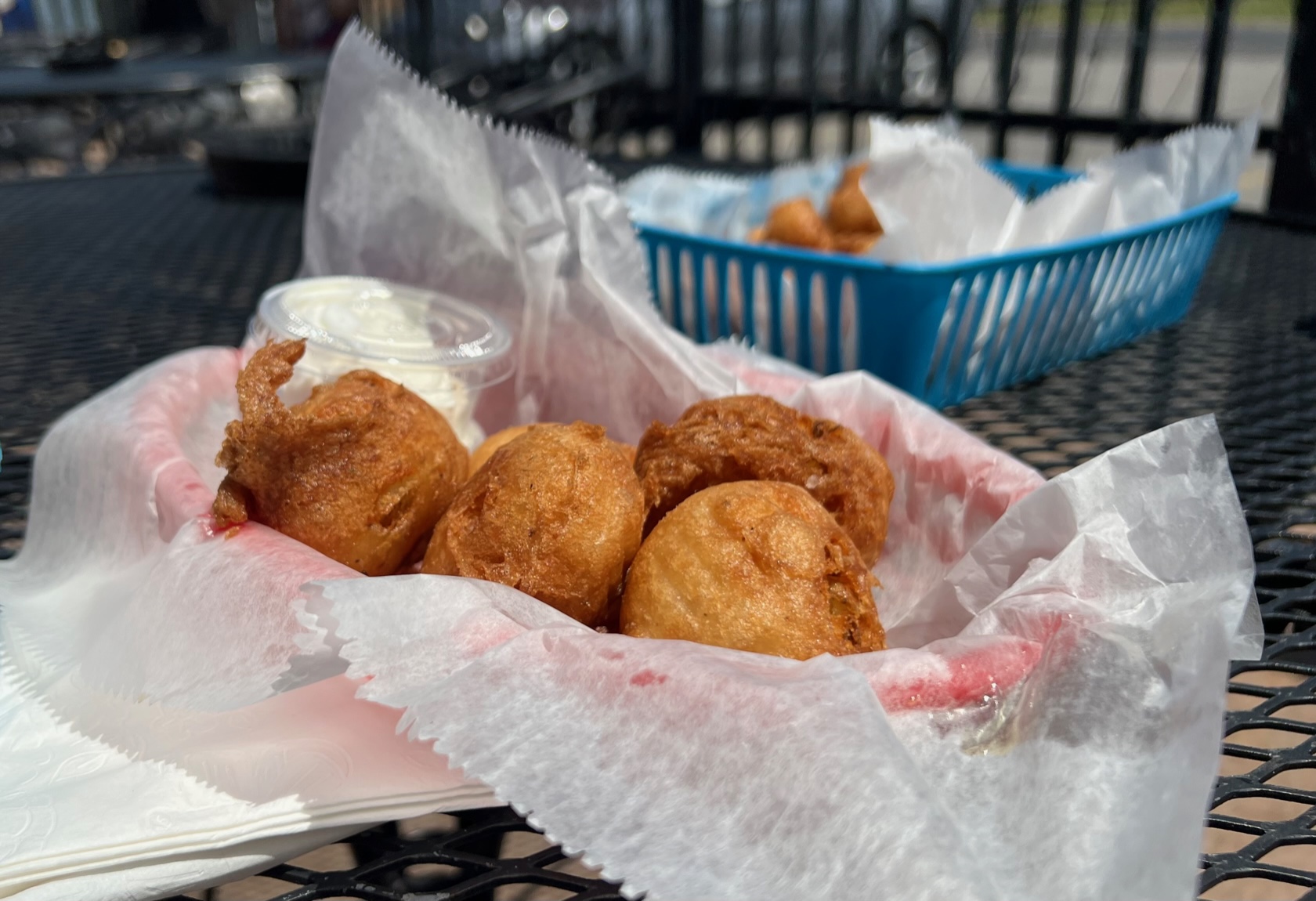 On an outside table at Boomerang's Bar & Grill, there is a parchment paper lined basket of boom balls, an appetizer of fried mashed potatoes. Photo by Alyssa Buckley.
