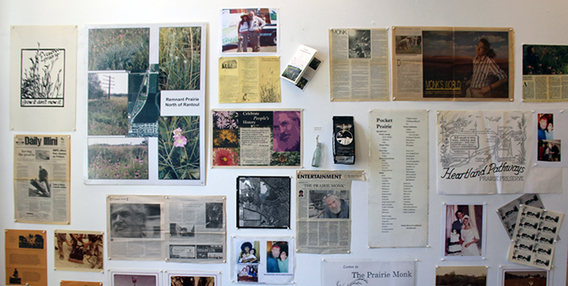 Newspaper clippings, photos, and other Dave Monk memorabilia attached to a large white wall. Photo by Debra Domal.
