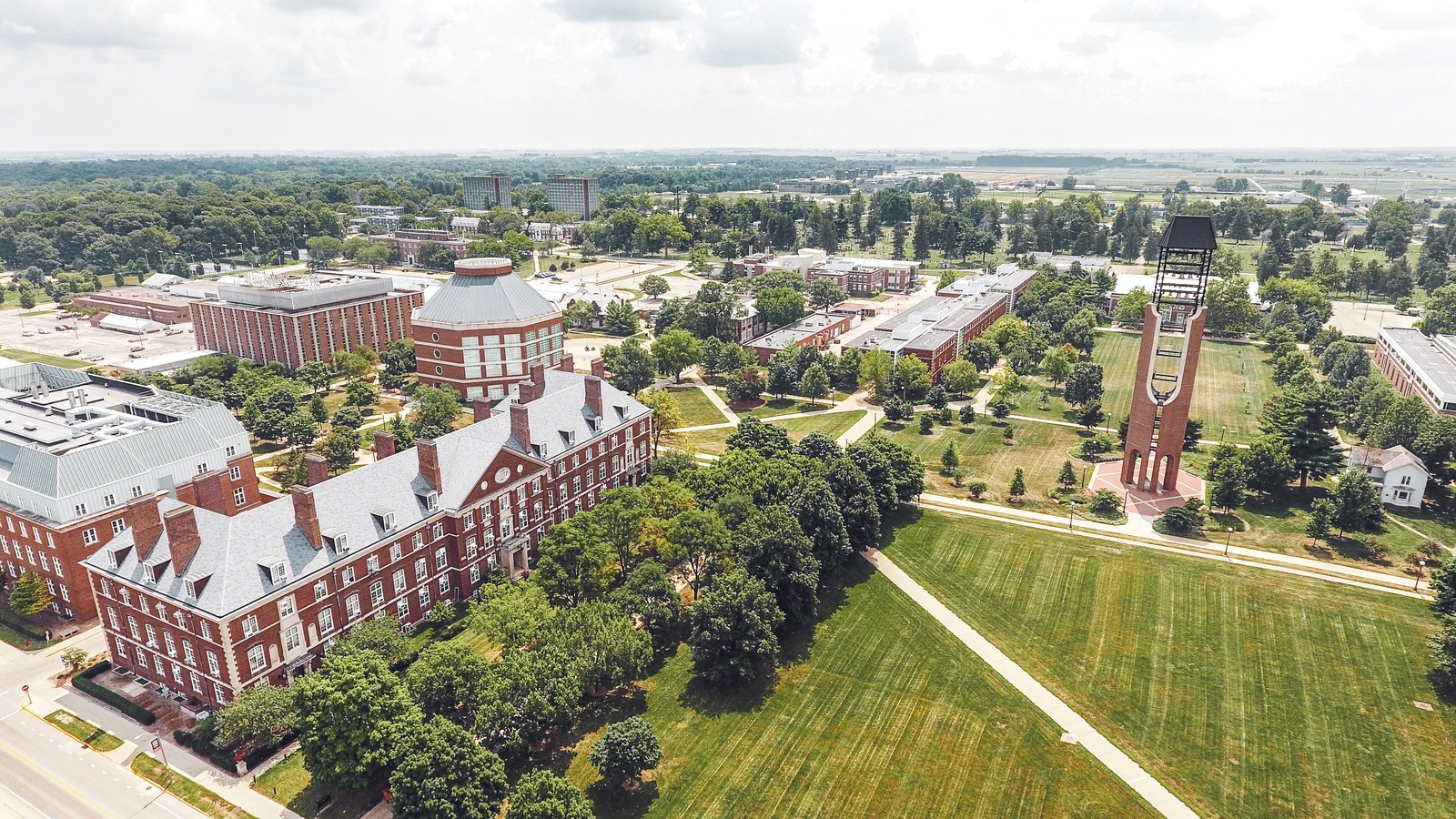 A bird's eye view of the College of ACES at the University of Illinois. The grass is green and the tress are lush.