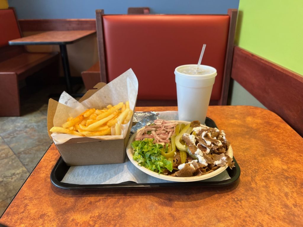 At Shawarma Joint in Urbana, Illinois, there is a gyro bowl lunch special with a side of fries and a soda in a white styrofoam container. Photo by Alyssa Buckley.