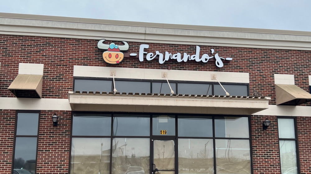 The exterior of Fernando's restaurant in North Champaign has the taco truck's logo of a cow and "Fernando's in white in a plaza. The windows are covered in brown paper, and the address 519 is visible on the window. Photo by Alyssa Buckley.