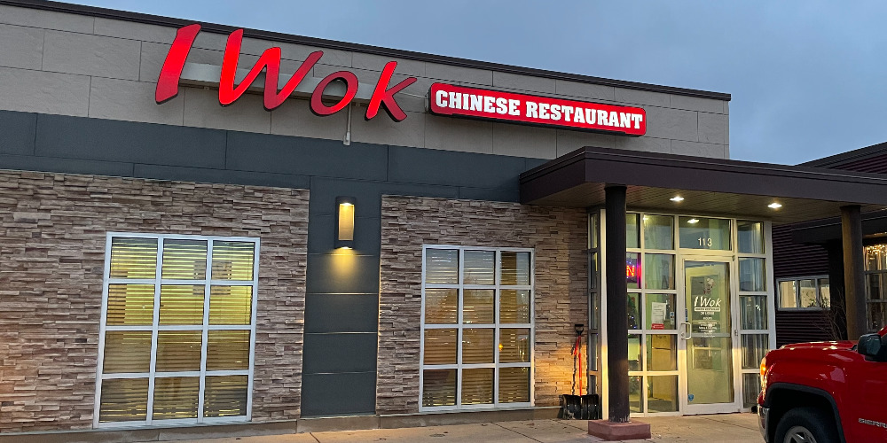 The exterior of I-Wok in Savoy, Illinois has lit up red signage on a weekday evening. Photo by Carl Busch.