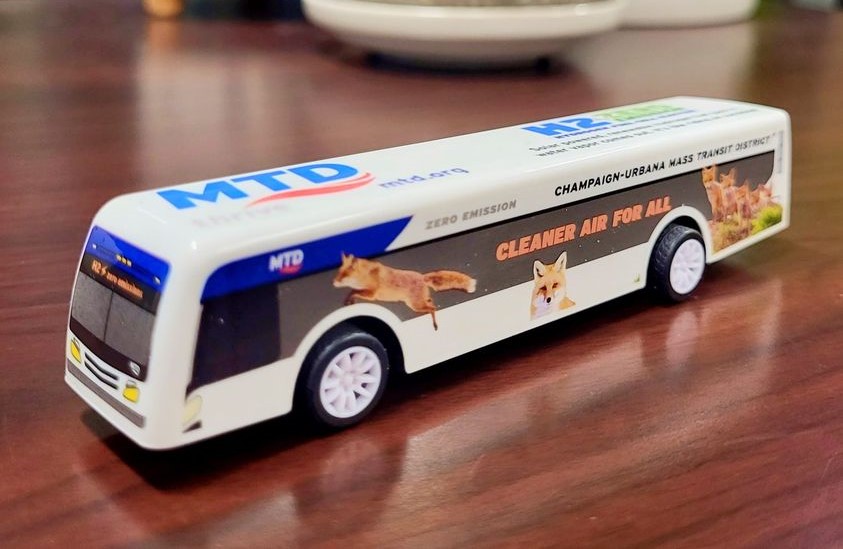 A toy version of an MTD bus sits on a wooden countertop