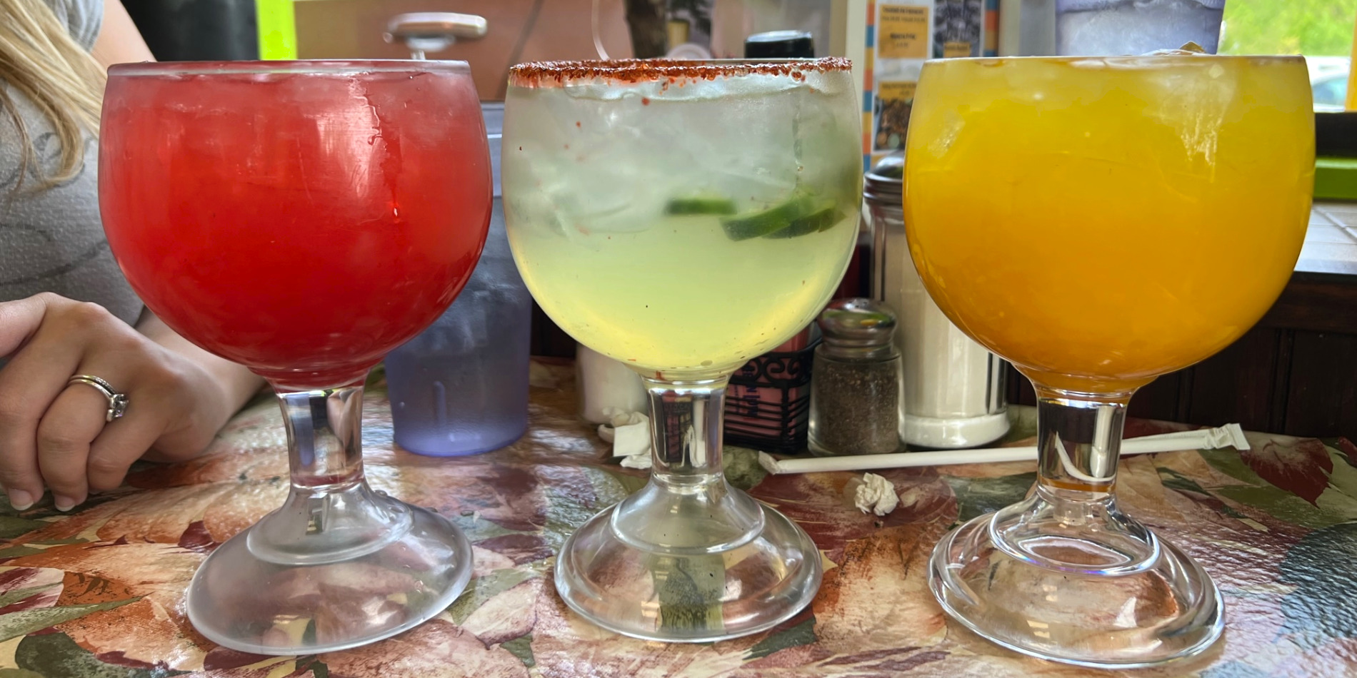 Three margaritas from Huaraches Moroleon in Urbana, Illinois are full. From the left, there is a strawberry one, a spicy jalapeno one, and a mango margarita. Photo by Alyssa Buckley.