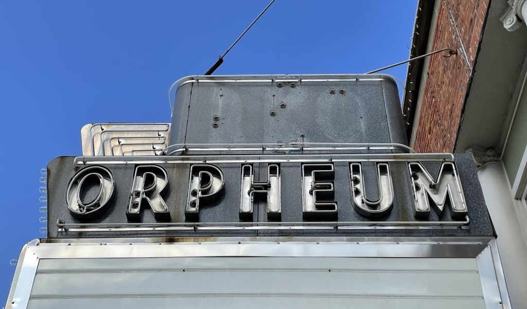A marquee theater sign that is gray metal, and says orpheum in block letters.