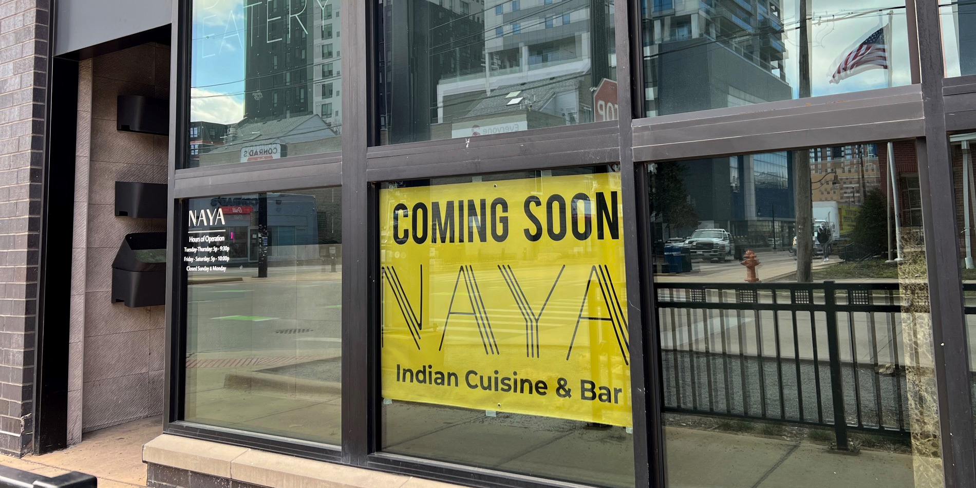 Outside NAYA restaurant, there is a yellow banner reading "Coming soon: NAYA Indian Cuisine & Bar." Photo by Alyssa Buckley.