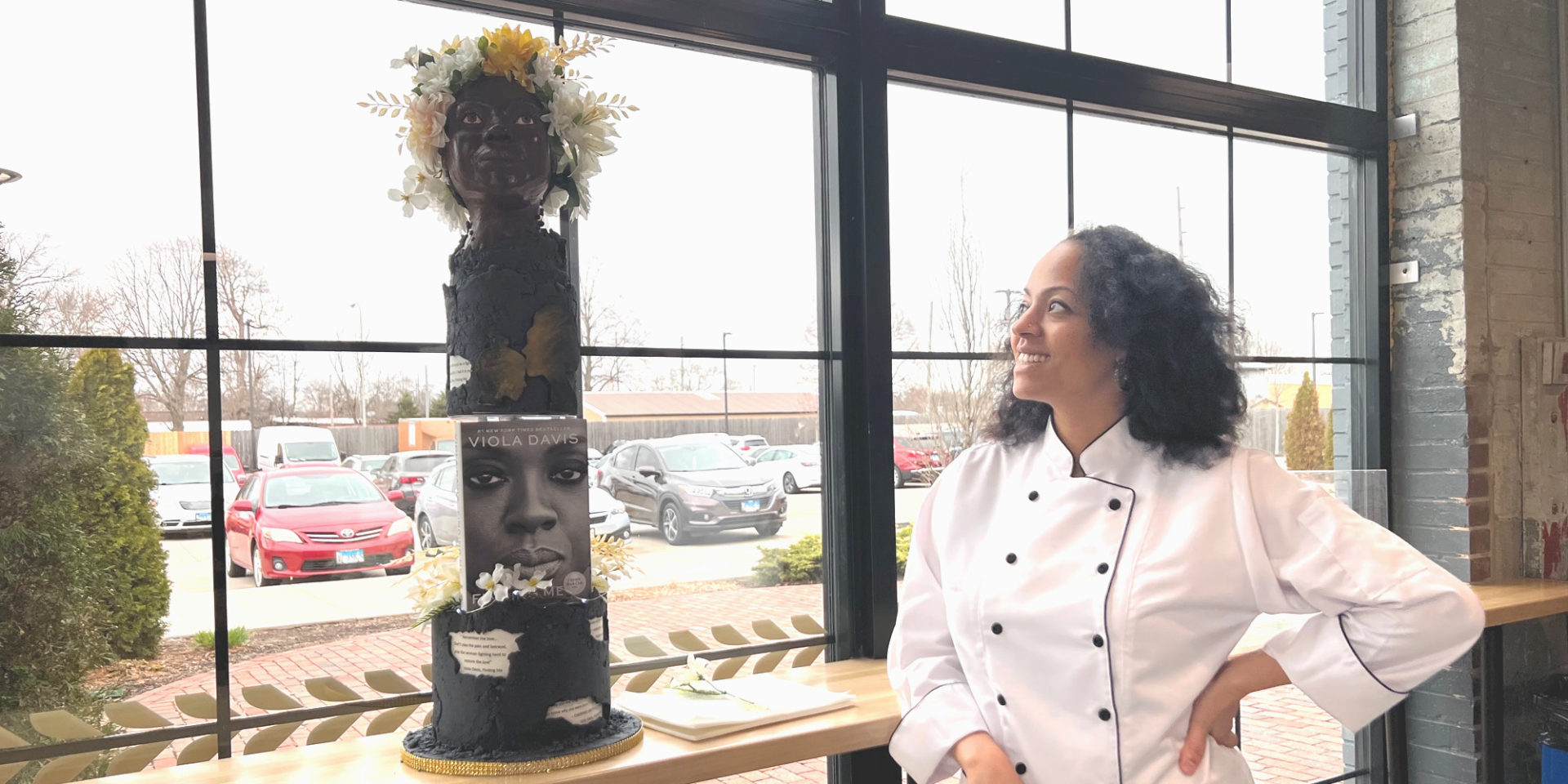 Cake Artist Tiara Winfield looks at her cake for the Edible Book Festival which she made in the likeness of Viola Davis to scale with a two tiered cake and edible book. Photo by Alyssa Buckley.